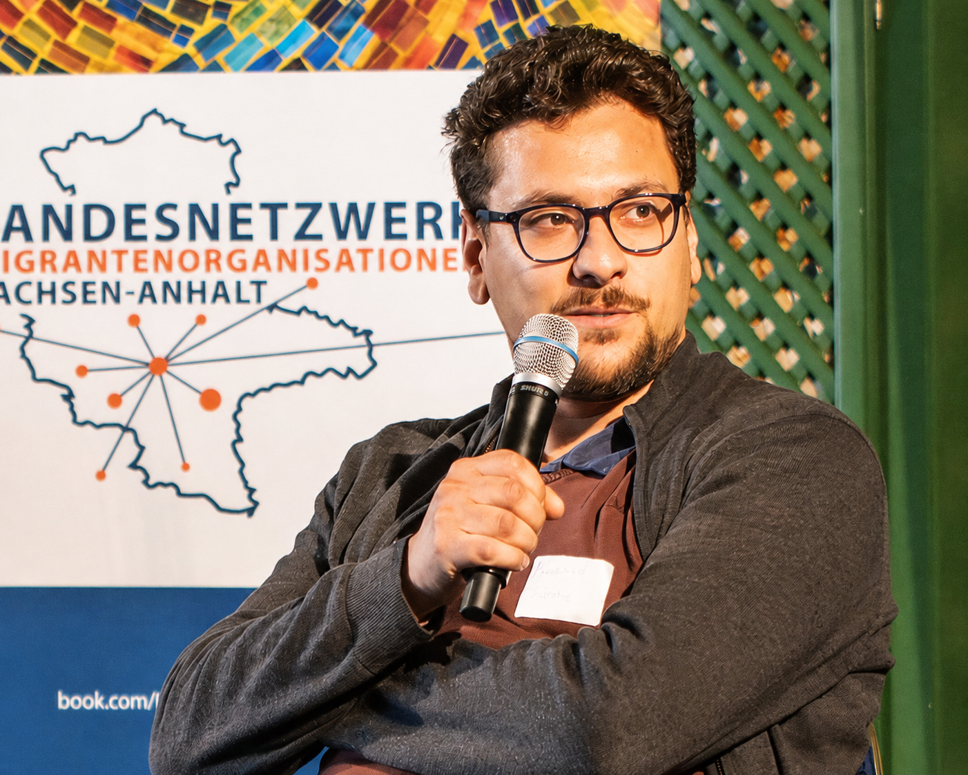 Mohammed Ali Chahrour spricht bei einer Veranstaltung in ein Mikrofon